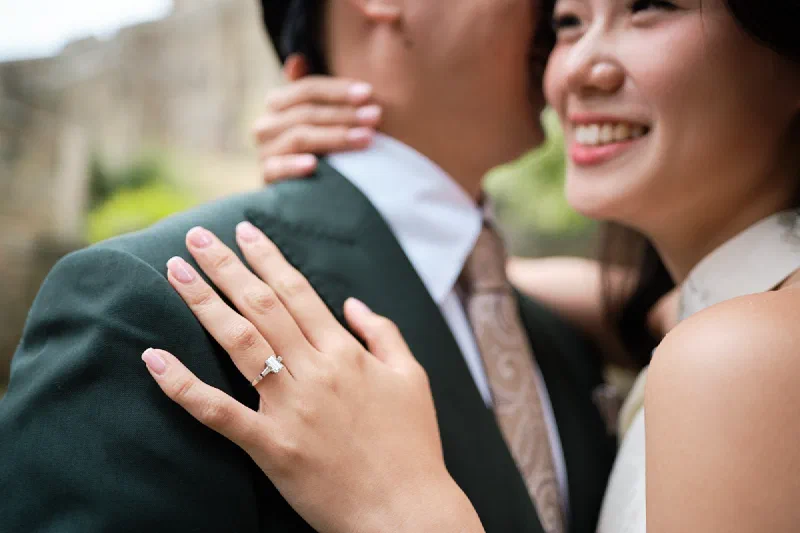 Close photograph of a newly engaged couple and their ring